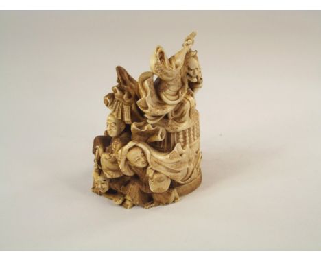 OKIMONO.A 19th century carved ivory Japanese okimono featuring a long haired, horned figure wielding an axe, below him four o
