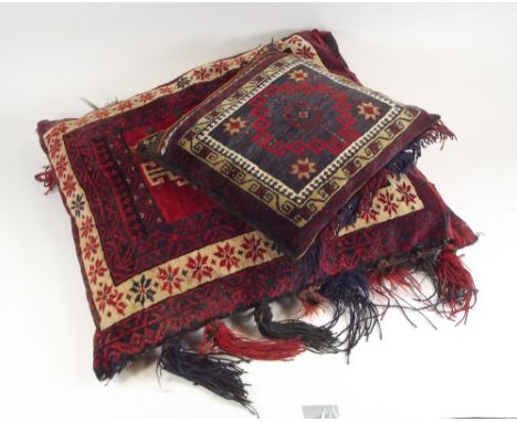 PERSIAN RUG CUSHIONS.A large Persian wool cushion with tassels,70 x 60cm & one smaller cushion, 36 x 36cm.