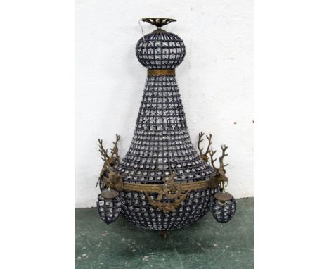 A chandelier decorated with four stags heads.  Height +/- 93 cm, diameter +/- 47 cm. 