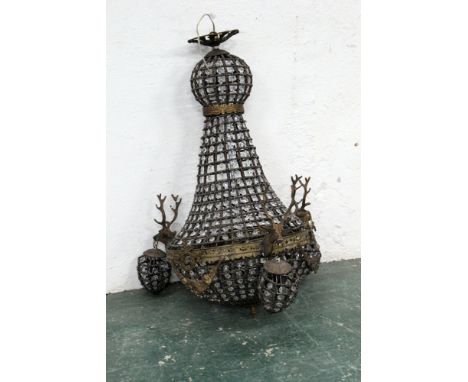 A chandelier decorated with three stags heads.  Height +/- 77 cm, diameter +/- 38 cm.