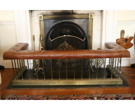 A late Victorian brass Club Fender, with deep buttoned leather top (some wear) supported by 25 narrow brass pillars on a plin