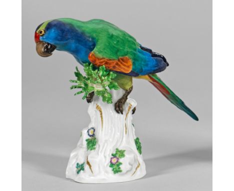 Papagei Auf hohem, teilw. mit plastischen Blumen und Blättern belegten, goldakzentuierten Baumstammsockel sitzender Papagei. 