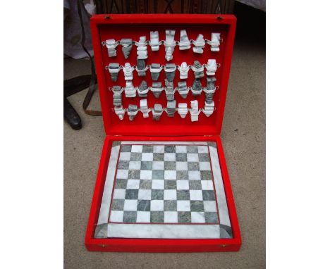 A cased soapstone chess board with pieces. 