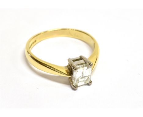 A VINTAGE 18CT GOLD AND DIAMOND SOLITAIRE RING the rectangular step-cut stone approximately 0.68cts, claw set in white betwee