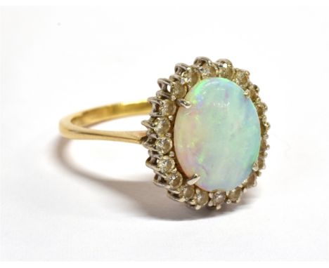 A CONTINENTAL 18CT GOLD, OPAL AND DIAMOND OVAL CLUSTER RING centred with an oval-cabochon white-opal (chipped) displaying a p