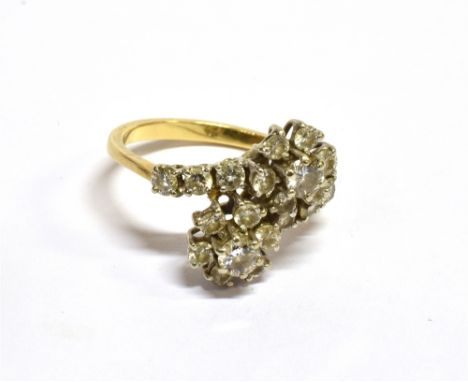 A VINTAGE 18CT GOLD AND DIAMOND TWIN-CLUSTER CROSS-OVER RING in the form of two round brilliant diamond graduated seven-stone