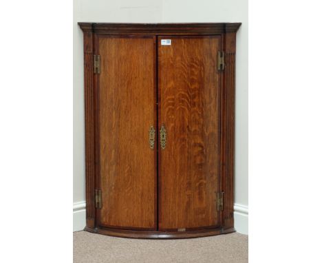 Early 19th century oak and mahogany banded wall hanging corner cupboard, bow front, with fluted uprights, W68cm, H88cm   Cond