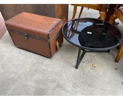 A COFFEE TABLE WITH METAL FRAME AND GLASS TOP 23.5" DIAMETER AND A TRUNK