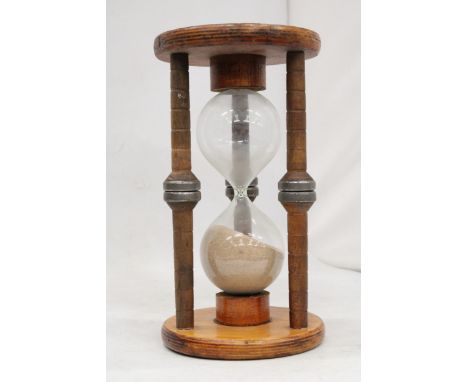 A LARGE SAND TIMER WITH A STAND MADE OF AN ORIGINAL MILL RELIC, HEIGHT 28CM