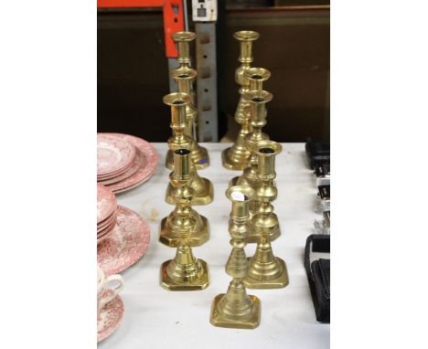 NINE VINTAGE BRASS CANDLESTICKS