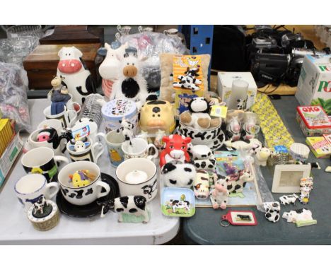 A LARGE COLLECTION OF COW RELATED ITEMS TO INCLUDE COOKIE JARS, MUGS AND CUPS, FIGURES, CRUETS, TOAST RACK, A TIE, ETC