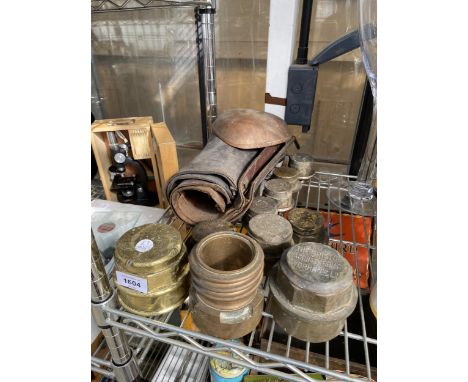 AN ASSORTMENT OF VINTAGE BRASS HUB CAPS AND LEATHER CUFFS