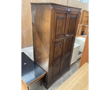 AN OAK WARDROBE WITH TWO LINEN FOLD DOORS, 37" WIDE