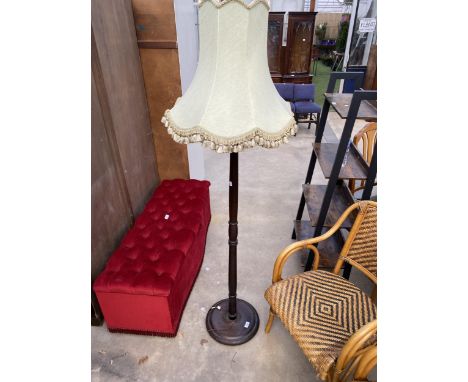 A STANDARD LAMP ON TURNED COLUMN WITH SHADE