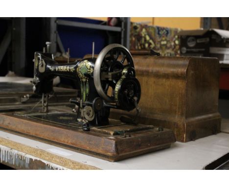 A VINTAGE VIBRA SEWING MACHINE WITH WOODEN CASE