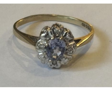 A MARKED 9 CARAT GOLD RING WITH CENTRE AQUAMARINE SURROUNDED BY NINE DIAMONDS SIZE K/L