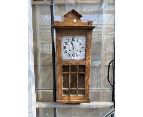 A VINTAGE OAK CASED CHIMING WALL CLOCK