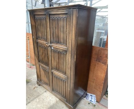 AN OAK WARDROBE WITH TWO LINEN FOLD DOORS, 49" WIDE