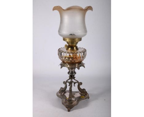 Duplex oil lamp circa early 20th century with later glass shade above glass reservoir and repousse decorated ep stand, overal