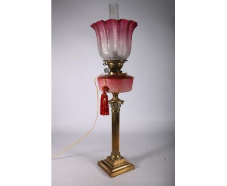 Youngs brass oil lamp circa early 20th century with later tinted glass shade and funnel above opaque glass reservoir and cori