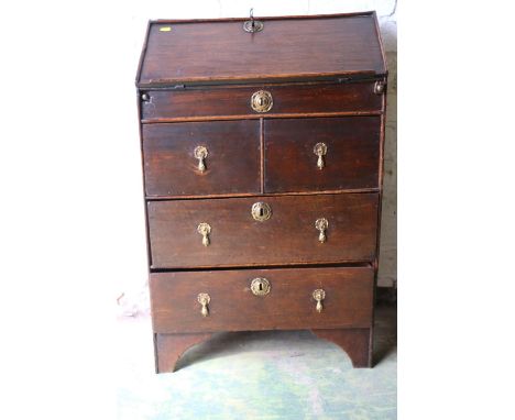 Antique oak fall front bureau of small proportions, the base with two short frieze drawers over two long drawers, raised on b