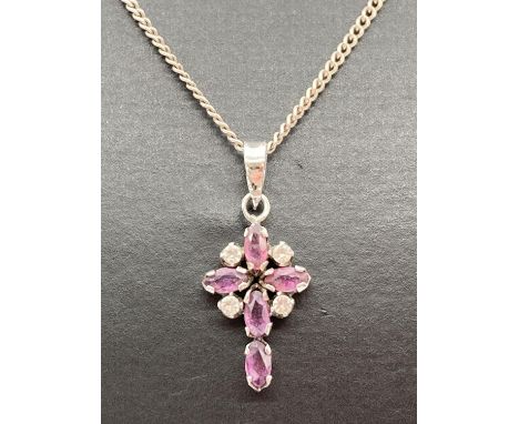 A silver, ruby and clear stone set cross pendant on an 18" fine curb chain with spring clasp. 925 stamped to bale, silver mar