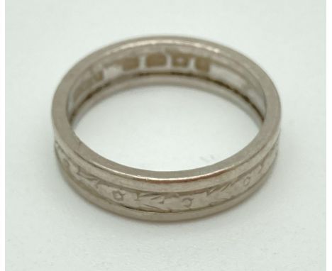 An 18ct white gold 44mm patterned wedding band. Full hallmarks to inside of band. Total weight approx. 4.2g.  Ring size K.