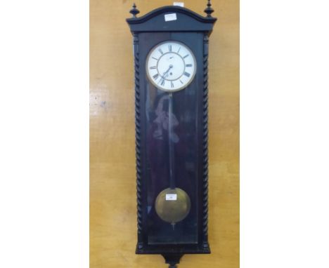 A Viennese Wall Clock, in an ebony case with white enamel face and Roman dial, approx 100 x 28 cms. The ebonised case with ba