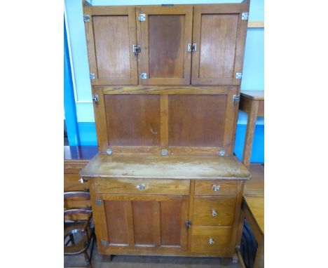 An Oak 1929 'Easiwork' Kitchen Cabinet, three top cupboards with shelves, middle cupboard with original flour dispenser, the 