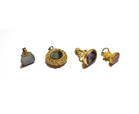 A gilt metal fob seal set with carnelian; a gilt metal fob seal set with purple glass, another gilt metal fob seal and a comp