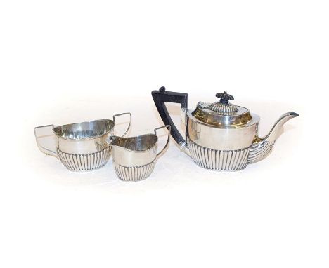 A three piece Victorian silver bachelor's tea service, by Maurice Baum, Sheffield, 1898, each piece with a part fluted lower 