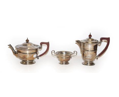 A silver three-piece tea service with wooden handles, by Adie Brothers Ltd, Birmingham, 1941, gross weight 29oz 10dwt, 917gr 