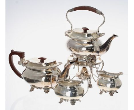 George V silver boat shaped tea set, comprising teapot, water pot over burner stand, cream jug and sucrier, cast with shell m