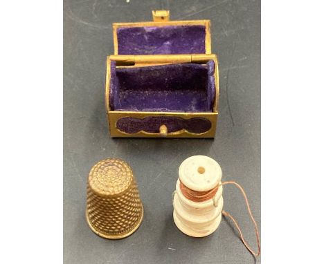 A vintage brass thimble in a brass trunk styled holder.