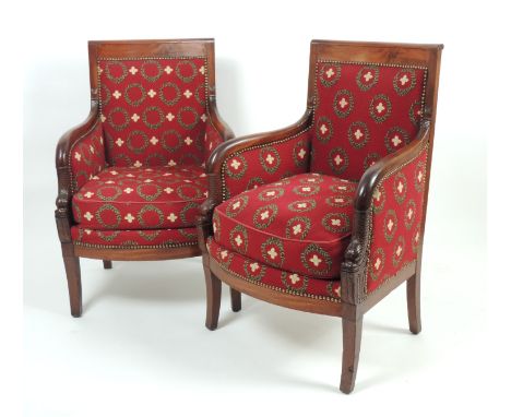Pair of French mahogany upholstered armchairs, in the Empire style, upholstered throughout in deep red tapestry fabric, the f