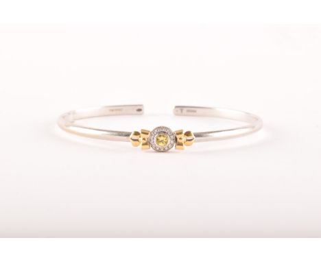 Theo Fennell. A 18ct white and yellow gold&nbsp; bangle set with a round brilliant cut yellow sapphire with an approximate we