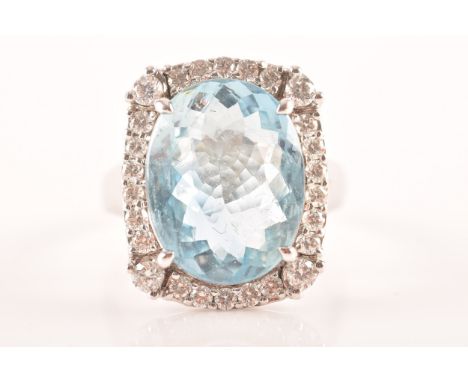 A 18ct white gold cluster ring, set to centre with an oval aquamarine with an approximate weight of 7.60 carats as measured i