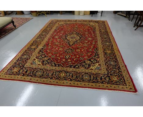 Red ground Kashmir Carpet, traditional medallion design, dark blue and multiple patterned borders, 3.45m x 2.45m