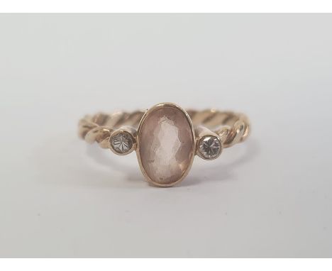 9ct gold, pale orange stone and diamond three-stone ring, the central oval pale orange stone 8mm x 4mm flanked by two diamond