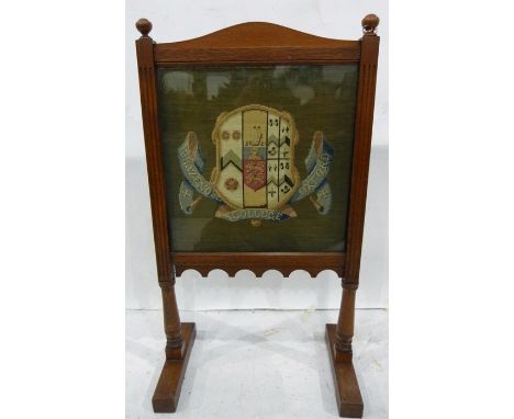 Oak firescreen with arched top, set with a woolwork tapestry depicting the Arms of Brasenose College, Oxford, 94cm high 