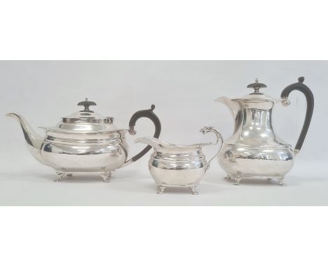 A 1920s matched three-piece silver teaset, reeded and repousse floral decoration to edges, claw feet, ebony finials and handl