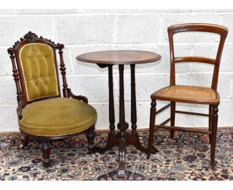 A Victorian walnut framed nursing chair with carved detail to the top stretcher above a button back and turned column legs.