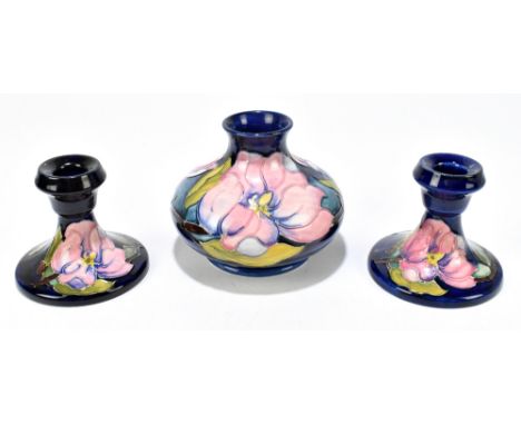 MOORCROFT; three pieces comprising a squat vase decorated in the 'Magnolia' pattern on a blue ground, height 11cm, together w