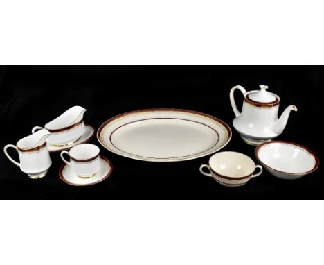 An extensive early 20th century and later harlequin dinner service with gilt geometric and floral detail inside a maroon bord