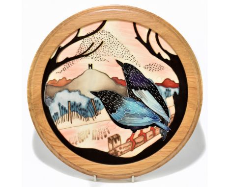 MOORCROFT; a circular wall plaque fitted in white oak frame decorated in the 'Starling Murmuration' pattern, overall diameter