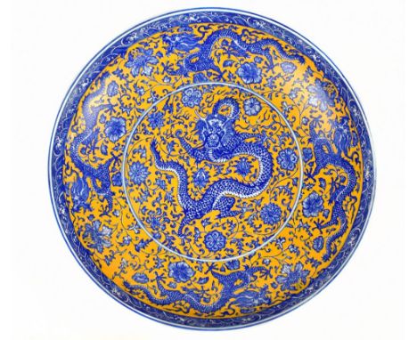 A modern Chinese circular bowl with transfer printed decoration representing a five clawed dragon and lotus flowers, bears se