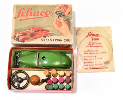 SCHUCO; a boxed tinplate clockwork telesteering car with ball pegs, ball, steering wheel, key and wire in original wrapping.P
