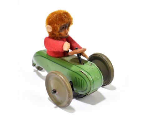 SCHUCO; a tinplate friction model of a three wheel motorcar with monkey driver, length 9cm.PROVENANCE: The Collection of Jack