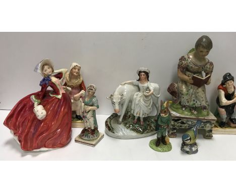 A 19th Century hand painted Staffordshire figure of The Village Maid in the manner of Obadiah Sherratt, she seated reading a 