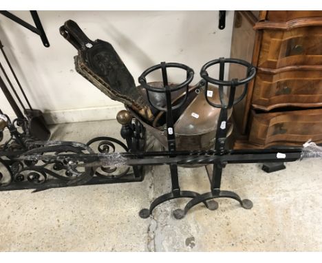 A pair of 20th Century wrought iron fire dogs with ale mullers, a carved oak pair of bellows decorated with portrait of King 